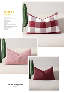 Detail of red checkered, striped and solid decorative pillow covers on a white sofa