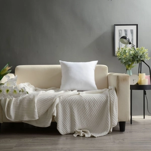 Close-up of minimalist white square pillow on fabric sofa with modern home decor detail