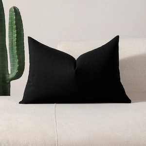 Modern minimalist solid black rectangular throw pillow cover on a beige sofa