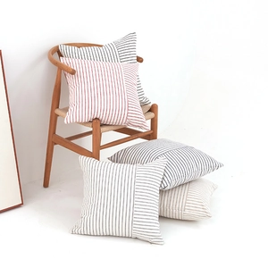 Fodera per cuscino a righe in misto cotone su sedia di legno in stanza minimalista