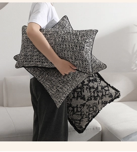 Detail of star-shaped jacquard pillow and square cushion with fringe and vintage pattern