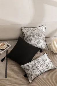 Détail de coussins de luxe français avec glands noirs et imprimés floraux sur canapé