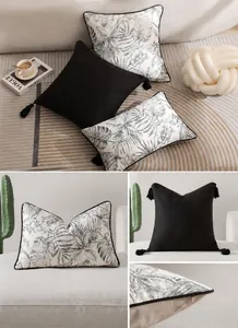 Détail de coussins de luxe français avec glands noirs et imprimé de feuilles tropicales
