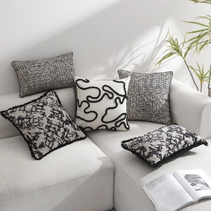 Modern black and white jacquard cushion covers with embroidery on a gray sofa