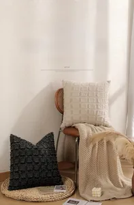Detailed view of textured square checkerboard cushion covers on a cozy wooden chair