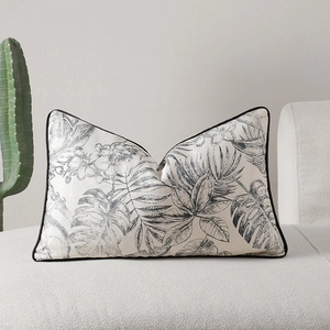 Coussin lombaire rectangulaire moderne avec imprimés tropicaux noir et blanc sur canapé