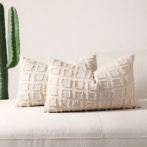 Minimalist cream polyester-cotton square tufted cushion covers on a sofa
