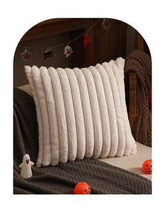 Detail of white plush pillow with soft textured stripes in a cozy holiday home setting