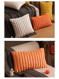 Detail of plush orange wide stripe throw pillow on a grey knit blanket for home decor