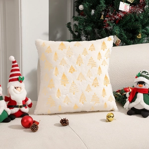 White faux fur Christmas pillowcase with gold tree pattern on a cozy sofa setting