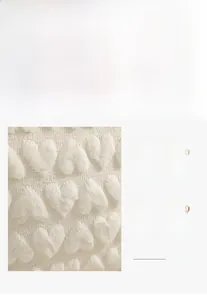 Detail view of cream plush pillow cover with 3D heart texture and fabric feature icons