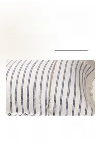 Detail of blue striped cushion cover with hidden zipper and fringed decorative edges