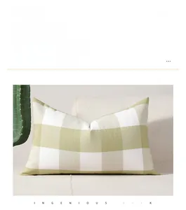 Close-up of green and cream plaid rectangular lumbar pillow on a cozy sofa setting