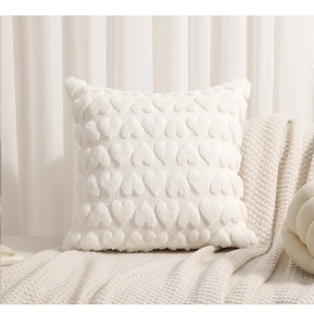 Detailed view of 3D embroidered hearts on a soft plush white decorative pillow case