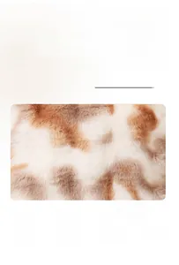 Detailed close-up of soft brown and white tie-dye faux fur pillow cover fabric texture