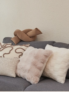 Detail of luxury lamb wool cushion covers with various plush textures on a modern sofa