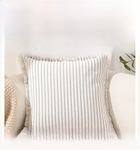 Detail of gray striped polyester cotton pillow cover featuring decorative fringe edges