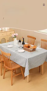 Detail of blue and white checkered waterproof tablecloth on a rustic wooden dining table