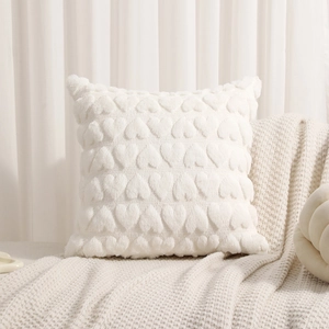 White heart textured plush decorative throw pillow on cozy knit blanket