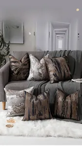 Détail de housses de coussin jacquard vintage avec passepoil sur un canapé gris