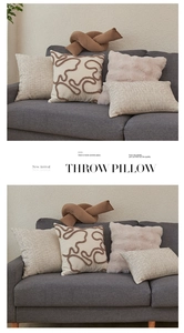 Detail of plush lamb wool throw pillows featuring 3D cord embroidery and geometric texture