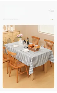 Detailed view of blue and white checkered tablecloth with a natural draped effect on wood