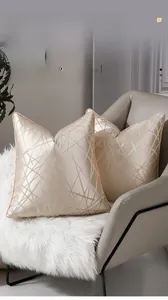 Gros plan de housses de coussin or champagne avec liserés et motifs géométriques