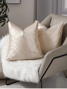Détail d'une taie d'oreiller en satin champagne géométrique de luxe avec bordure passepoilée