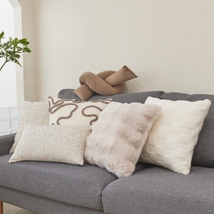Modern lamb wool pillow covers in neutral tones on a sofa for cozy living room decor