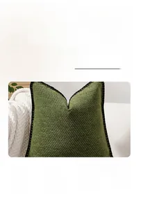 Detail of green corduroy pillow cover featuring decorative black crochet lace edging