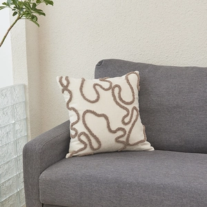 Modern minimalist white sherpa pillow cover with brown tufted wave texture on grey sofa