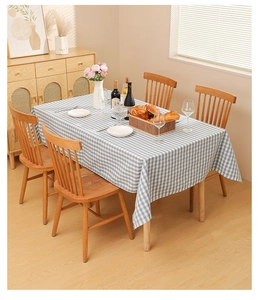 Close-up of blue and white checkered tablecloth with a natural drape on a wooden table