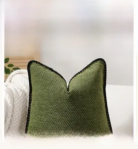 Macro detail of dark green chenille cushion cover with black crochet lace edging