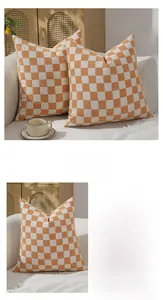 Detail view of orange and white checkerboard chenille cushion cover texture and seams