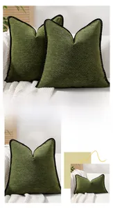 Detailed view of dark green chenille pillow cover with delicate black fringe border edge