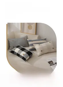 Detail of nautical lumbar pillow covers with decorative wooden buttons on a beige sofa