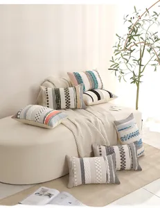 Detailed knit textures and tassels of bohemian tufted throw pillow covers on a soft sofa