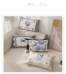 Detail of nautical lumbar pillows with ocean patterns and decorative wooden buttons on a sofa