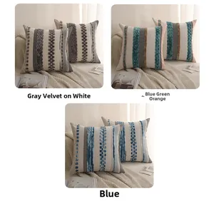 Close-up of tufted woven cushion covers with textured stripes and decorative fringe