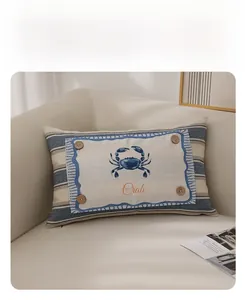 Detail of nautical crab pillow with wooden button and blue stripes on linen fabric