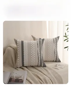Detail of bohemian tufted cushion cover with grey stripes and white textured tassels