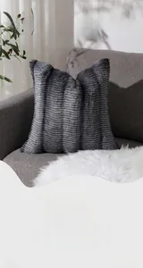 Dettaglio federa in peluche grigio strutturato con motivo a onde su divano moderno