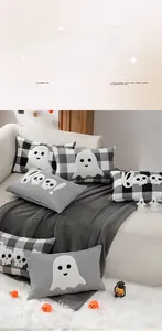 Dettaglio dei cuscini di Halloween con ricamo BOO su un set di divani bianchi eleganti