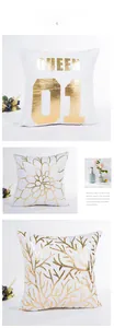 Detail of white decorative pillow covers with gold foil QUEEN text and floral patterns