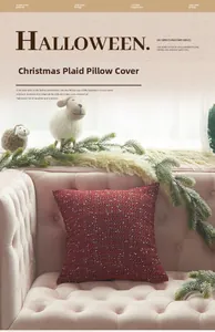 Close-up of red plaid knitted Christmas pillow cover on a pink tufted sofa with pine decor