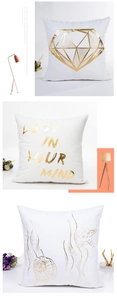 Detail of white square pillow covers featuring gold foil geometric and ocean patterns
