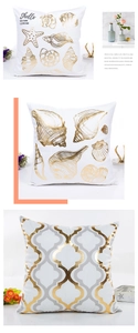 Detailed view of white pillowcases with gold stamped seashell and geometric clover patterns