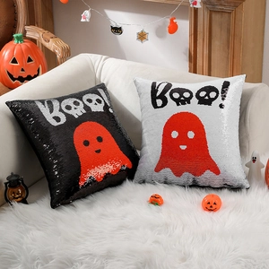 Set of two Halloween sequin pillows with reversible Boo ghost design on white sofa