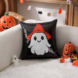Halloween sequin pillow with white ghost and red wizard hat on a cozy white sofa