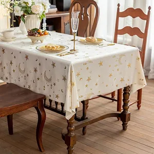 Nordic cream tablecloth with gold moon and star foil patterns on a wooden table